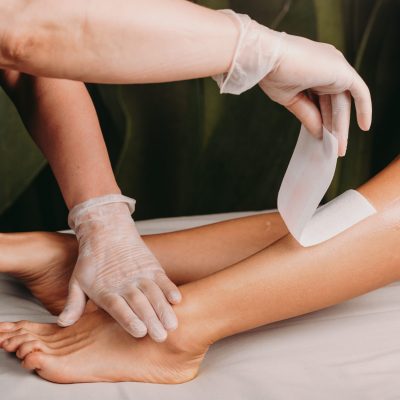 Caucasian lady waiting in a spa salon to finish her waxing session on legs